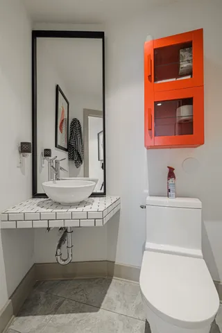 a bathroom with a toilet a sink and mirror