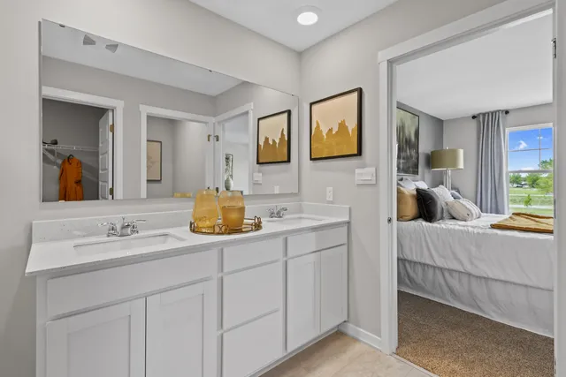 a en suite bathroom with a double vanity sink and mirror