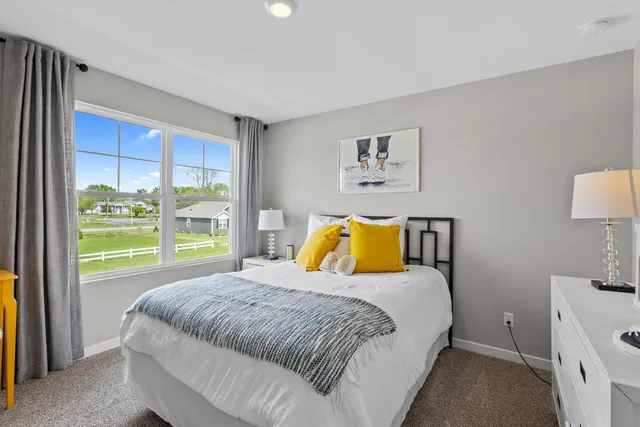 a bed sitting in a bedroom next to a window