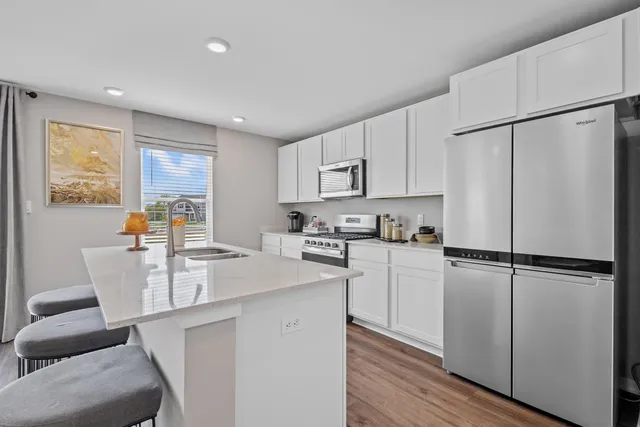 a kitchen with white cabinets and white appliances