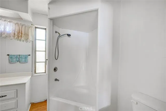 a white toilet sitting next to a shower