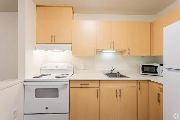a kitchen with stainless steel appliances a stove a sink and white cabinets