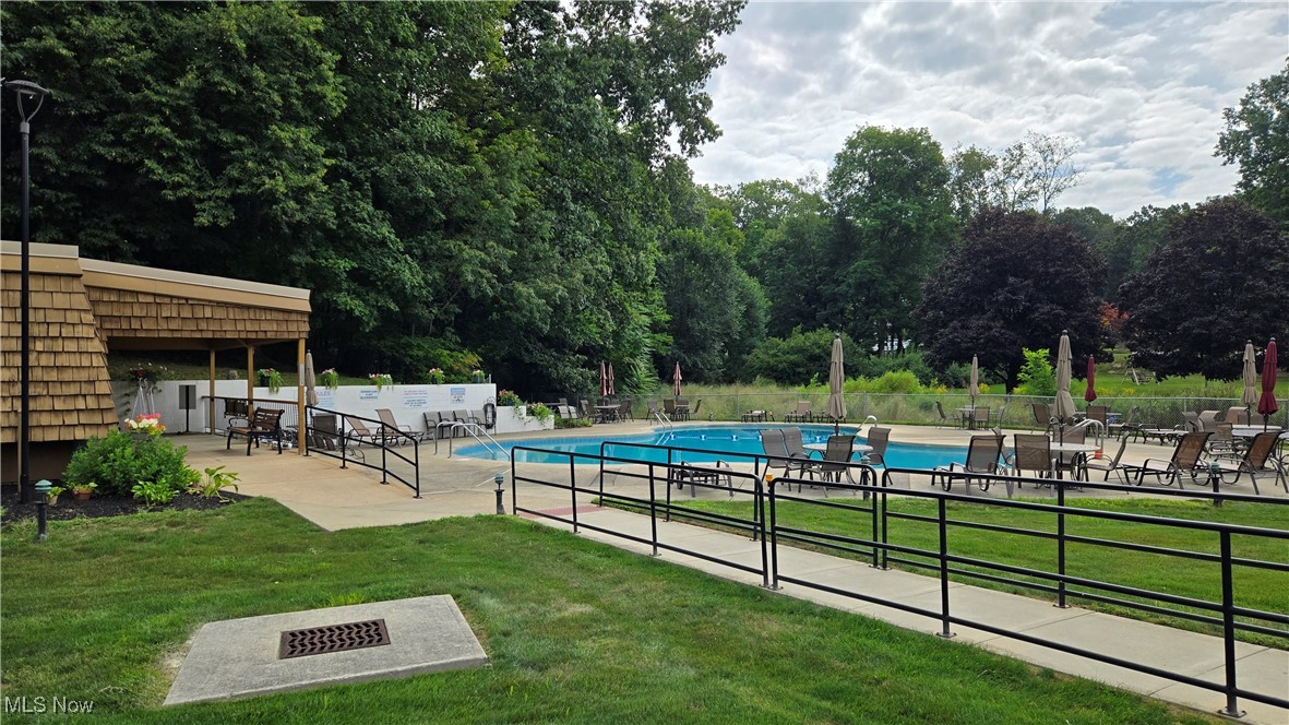 3068 Kent Road, Unit 210C Stow, OH 44224 - Photo 3 of 14 Community pool featuring a patio area and view of wooded area