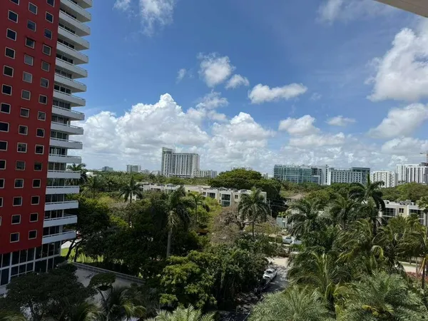 a front view of a multi story residential apartment building with yard and retail shops