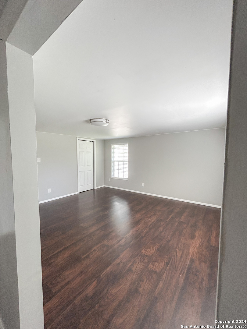 613 East Ireland Street Seguin, TX 78155 - Photo 17 of 42 an empty room with wooden floor and windows