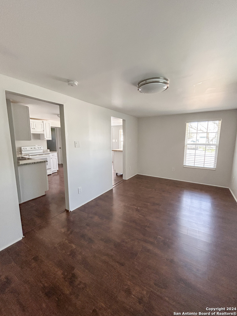 613 East Ireland Street Seguin, TX 78155 - Photo 22 of 42 wooden floor in an empty room with a window