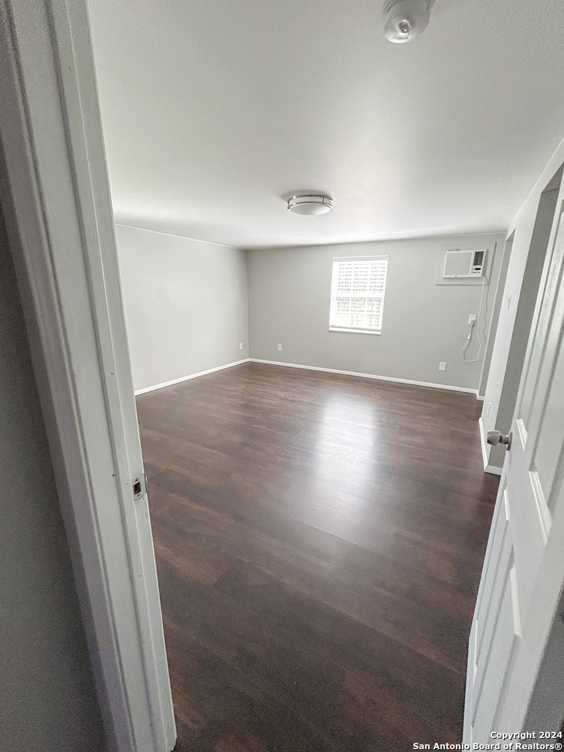 613 East Ireland Street Seguin, TX 78155 - Photo 23 of 42 en empty room with wooden floor and window