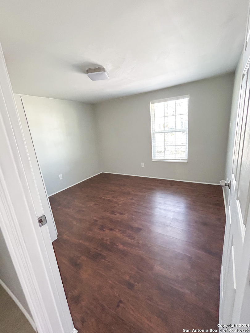 613 East Ireland Street Seguin, TX 78155 - Photo 27 of 42 an empty room with wooden floor and windows