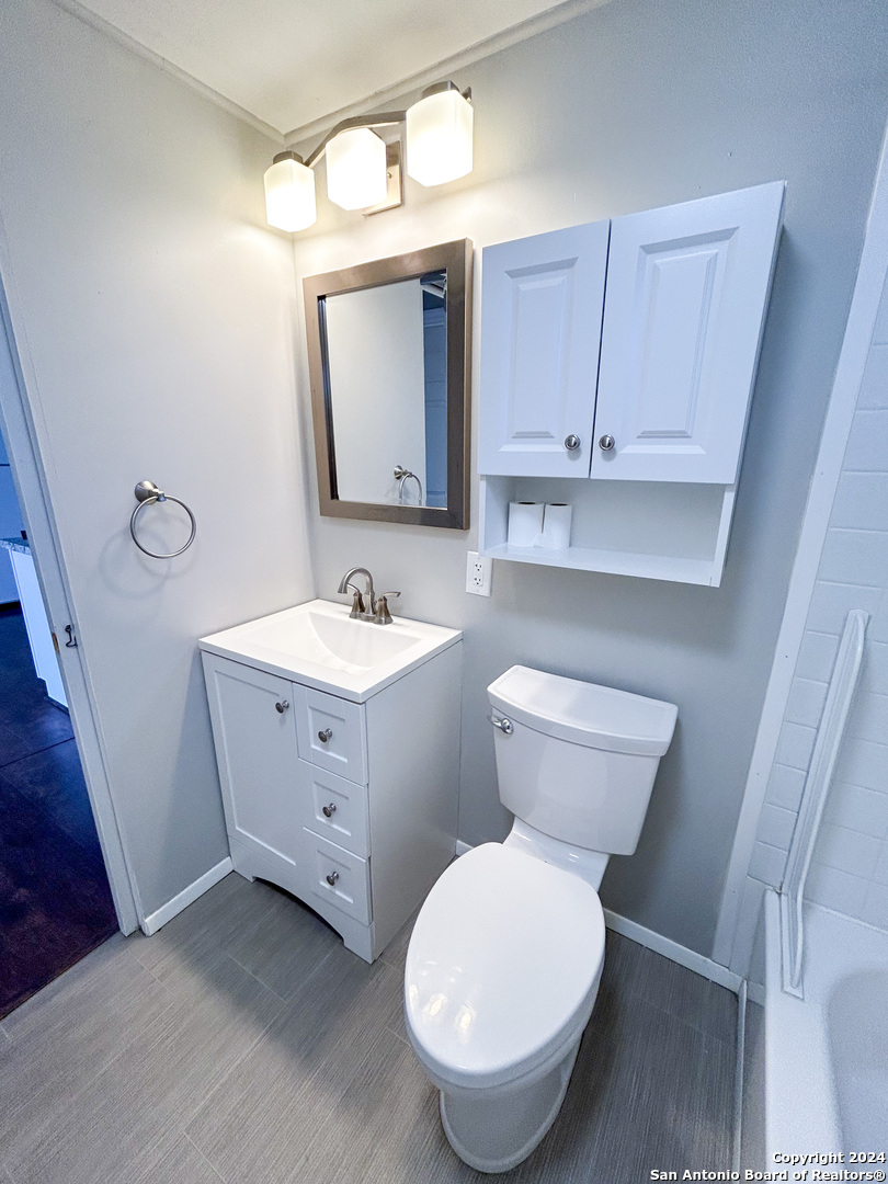 613 East Ireland Street Seguin, TX 78155 - Photo 32 of 42 a bathroom with a toilet sink and mirror