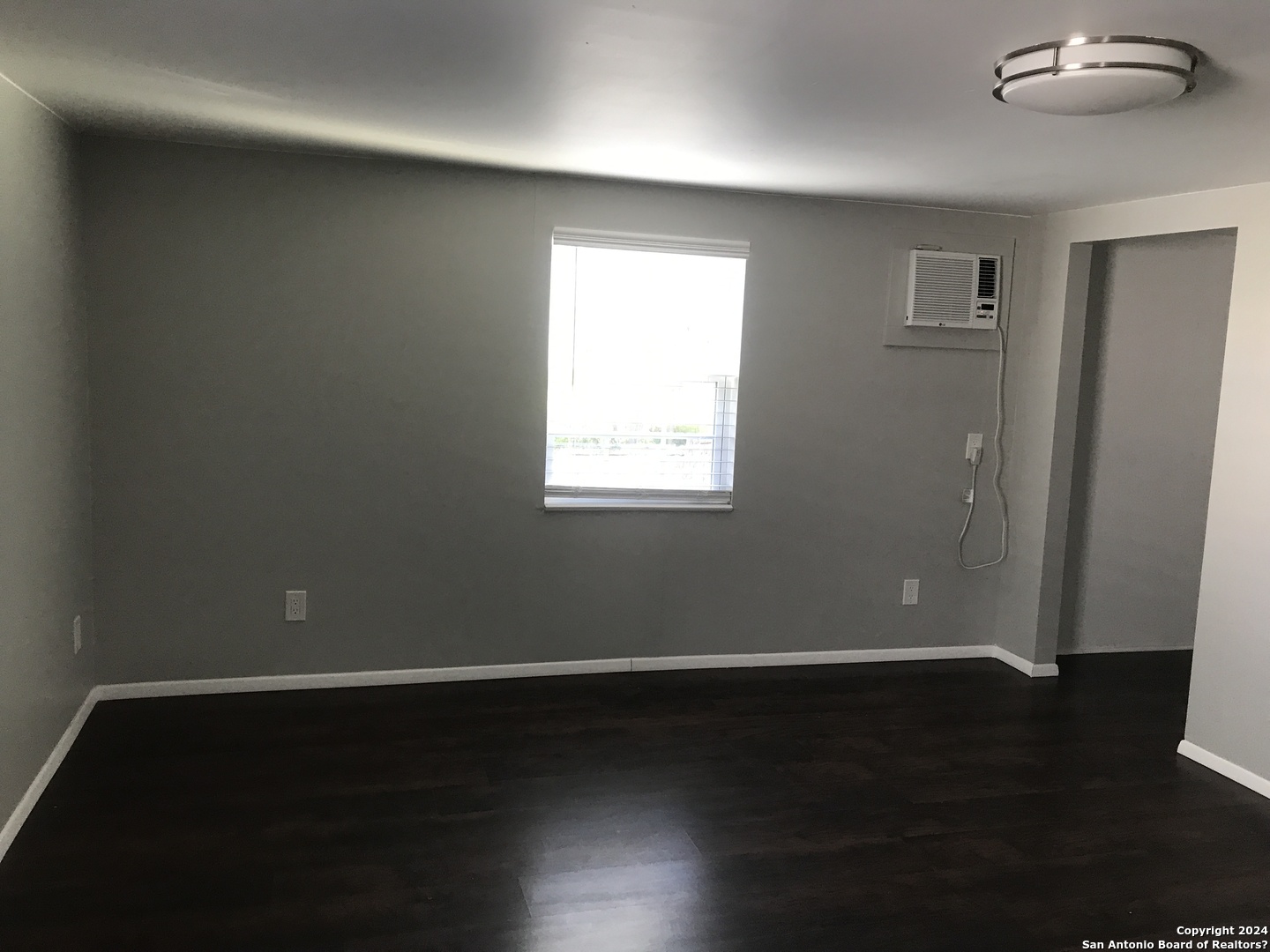 613 East Ireland Street Seguin, TX 78155 - Photo 7 of 42 a view of an empty room with wooden floor and a window