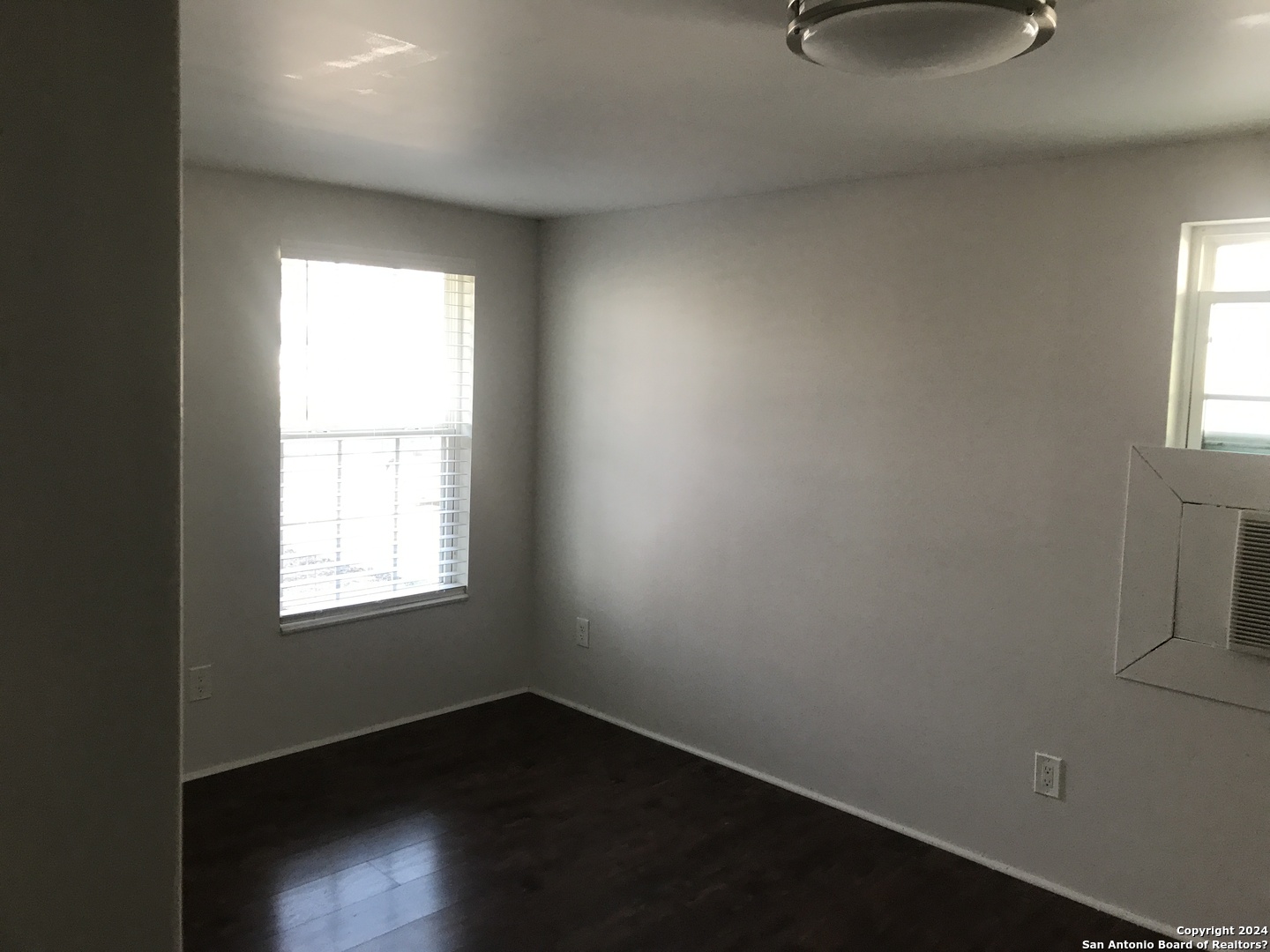 613 East Ireland Street Seguin, TX 78155 - Photo 8 of 42 an empty room with wooden floor and windows