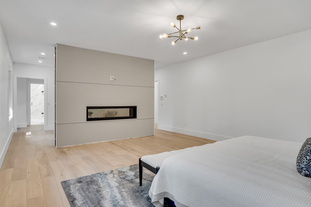 8 Winston Road Lexington, MA 02421 - Photo 25 of 42 a spacious bedroom with a bed and a chandelier