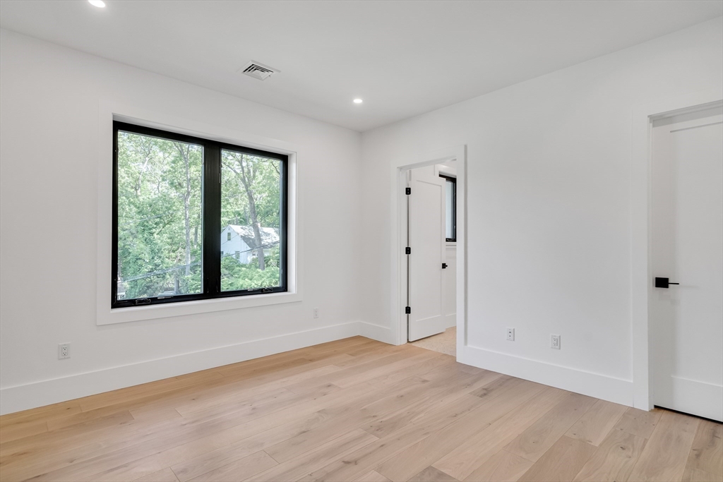 8 Winston Road Lexington, MA 02421 - Photo 32 of 42 a view of an empty room with a window and wooden floor