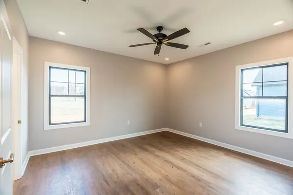 a view of a big room with wooden floor and windows
