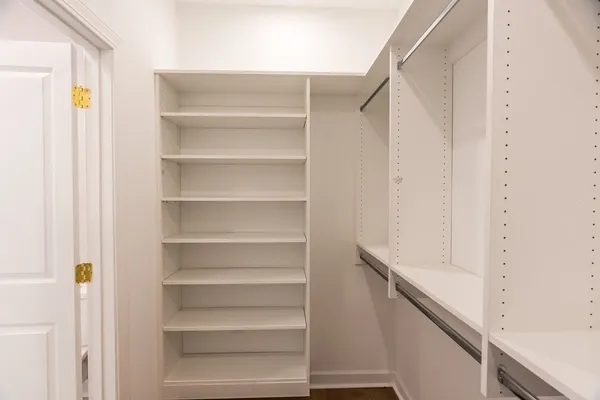 a view of walk in closet with empty racks