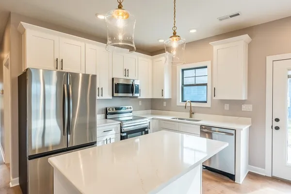 a kitchen with stainless steel appliances a refrigerator sink and microwave
