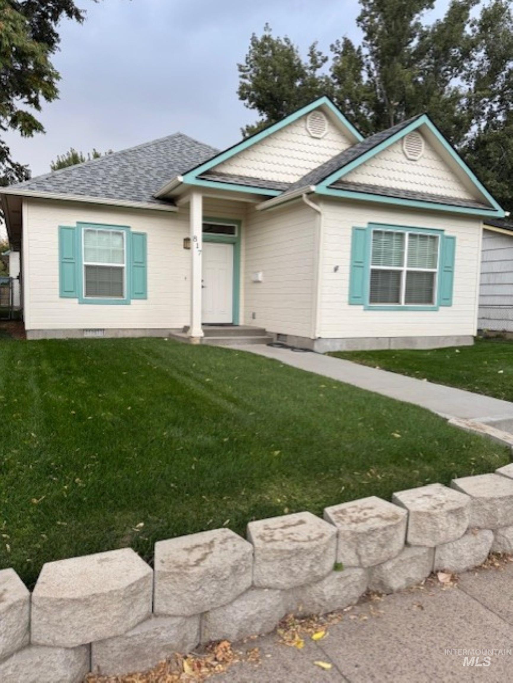 Ranch-style home with a front yard and roof with shingles