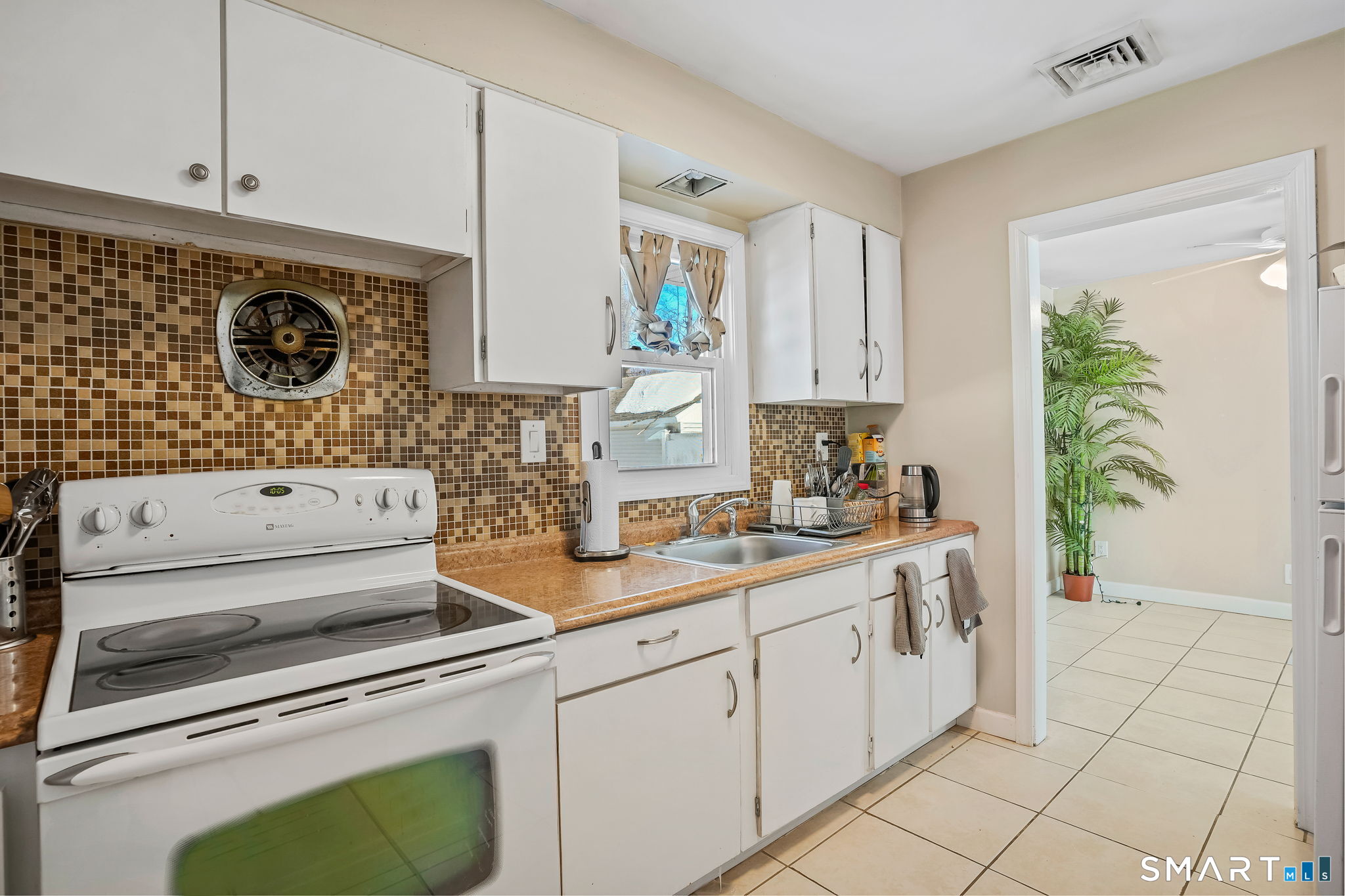 3460 Old Town Road Bridgeport, CT 06606 - Photo 11 of 34 a kitchen with a stove a sink and a refrigerator