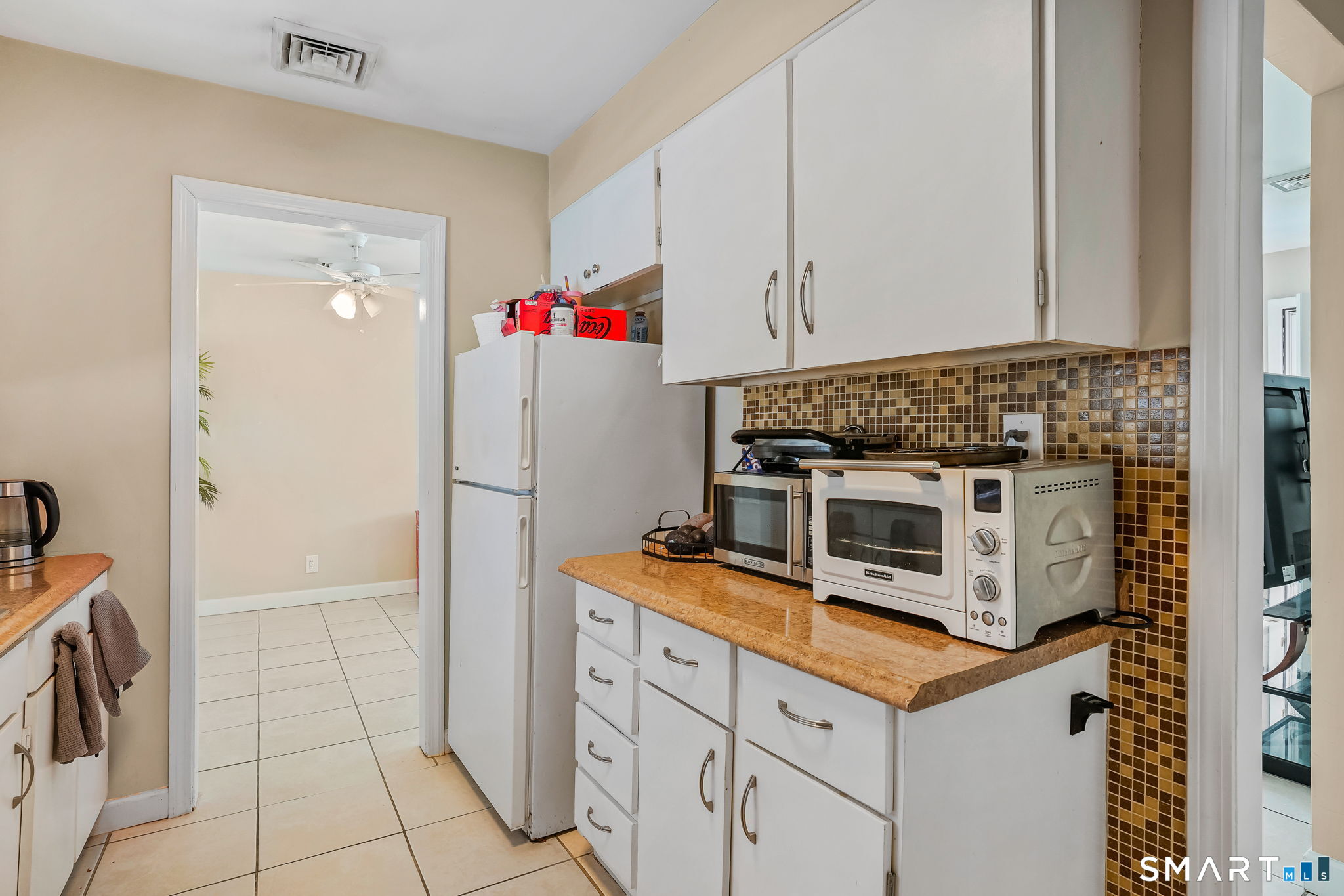 3460 Old Town Road Bridgeport, CT 06606 - Photo 12 of 34 a kitchen with white cabinets and white appliances