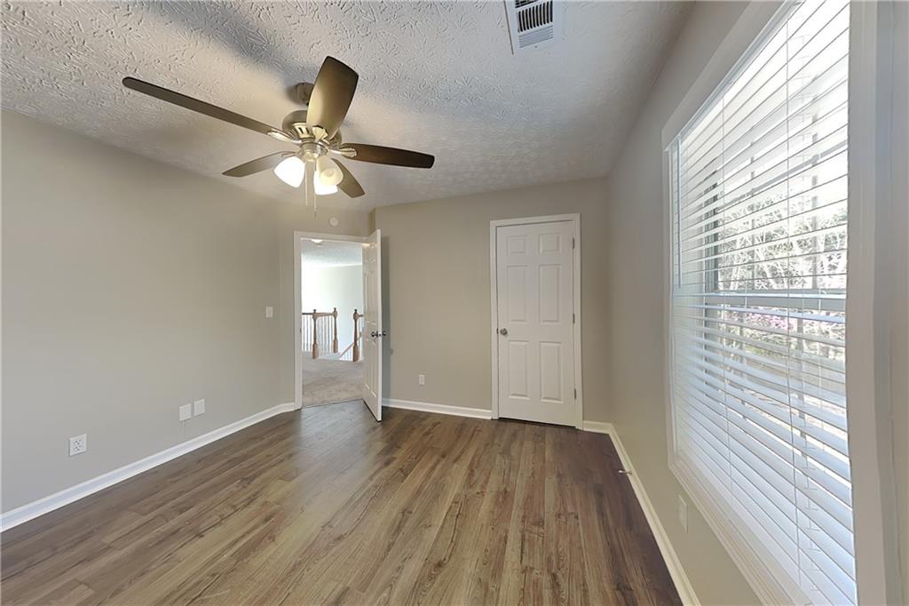 2730 Jona Trail Dacula, GA 30019 - Photo 12 of 19 a view of an empty room with wooden floor and a window