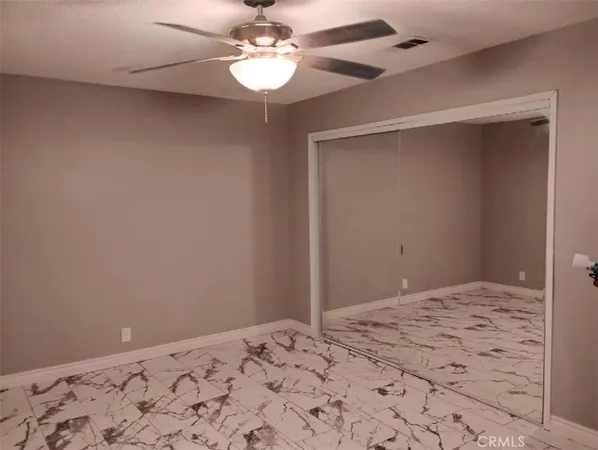 a view of a big room with a chandelier fan and closet