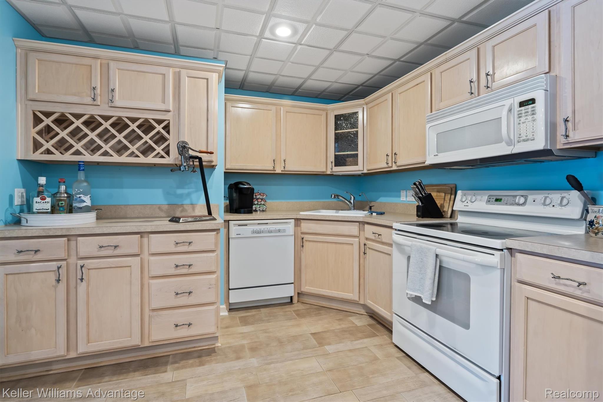 22878 Tree Top Court South Lyon, MI 48178 - Photo 33 of 75 Kitchen featuring extensive light wood-finish cabinetry, integrated wine storage, white appliances, and a drop ceiling with recessed lighting