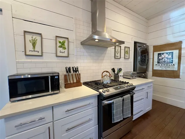a kitchen with stainless steel appliances granite countertop a stove and a microwave