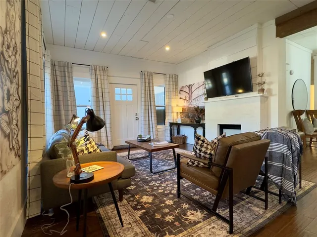 a living room with furniture a flat screen tv and a fireplace