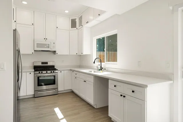 a kitchen with stainless steel appliances granite countertop a refrigerator sink and stove