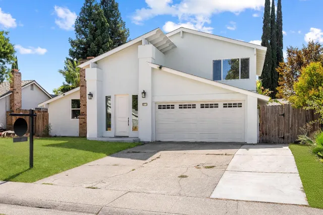 a view of a white house with a yard