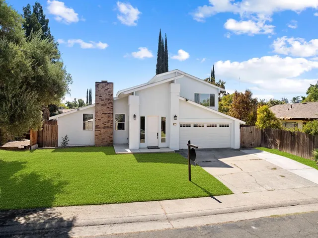 a view of a white house with a yard