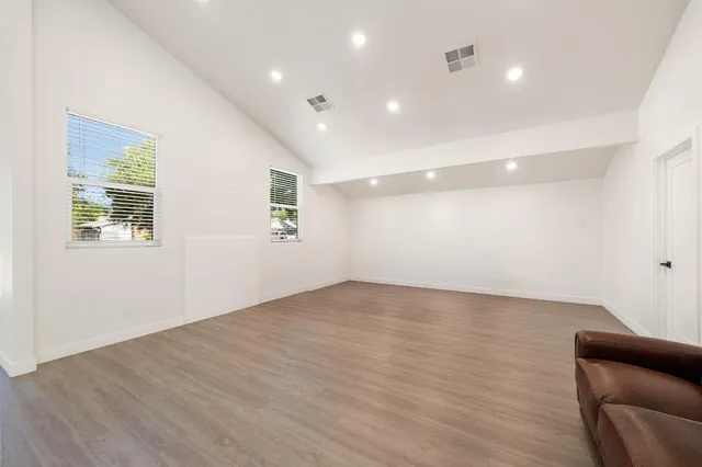 a big room with wooden floor and windows