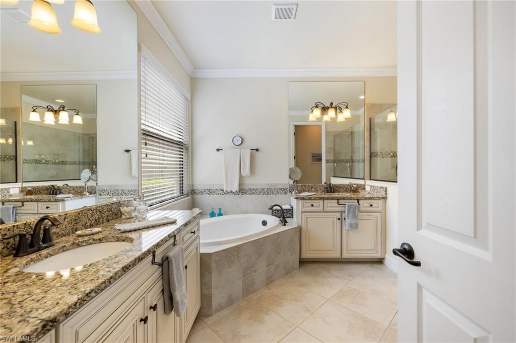 28529 Westmeath Court Bonita Springs, FL 34135 - Photo 13 of 49 a bathroom with a granite countertop sink mirror and a bathtub