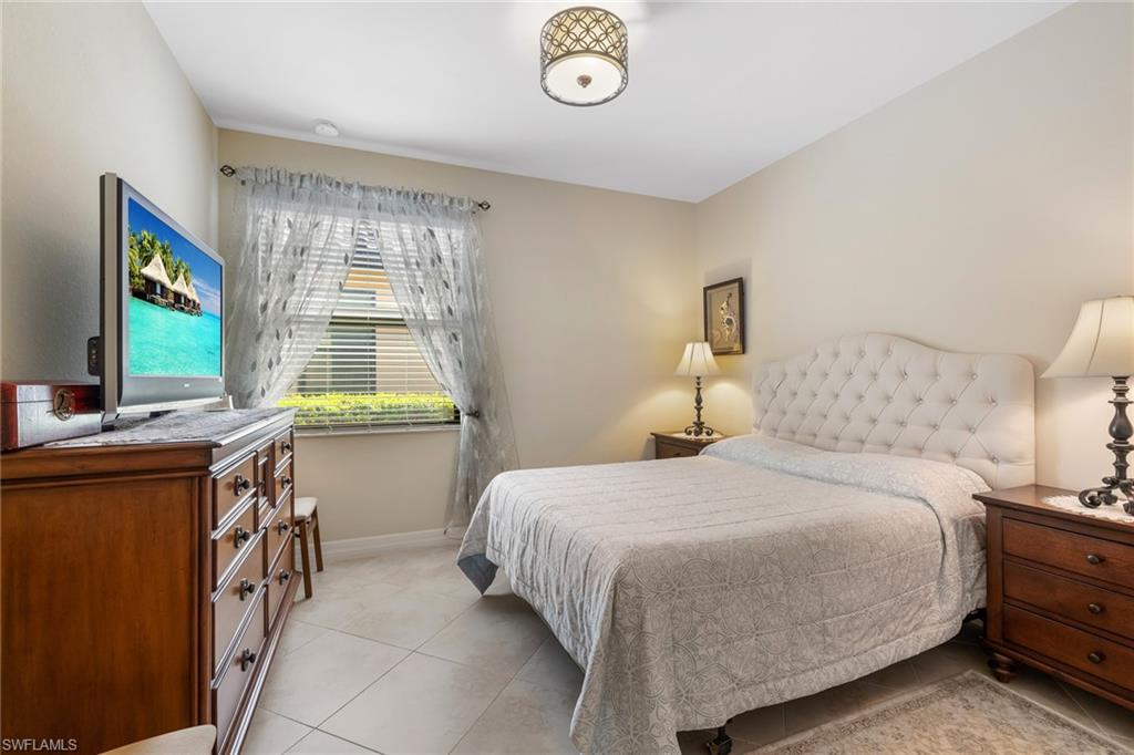 28529 Westmeath Court Bonita Springs, FL 34135 - Photo 16 of 49 a bedroom with a bed and a flat tv screen on dresser