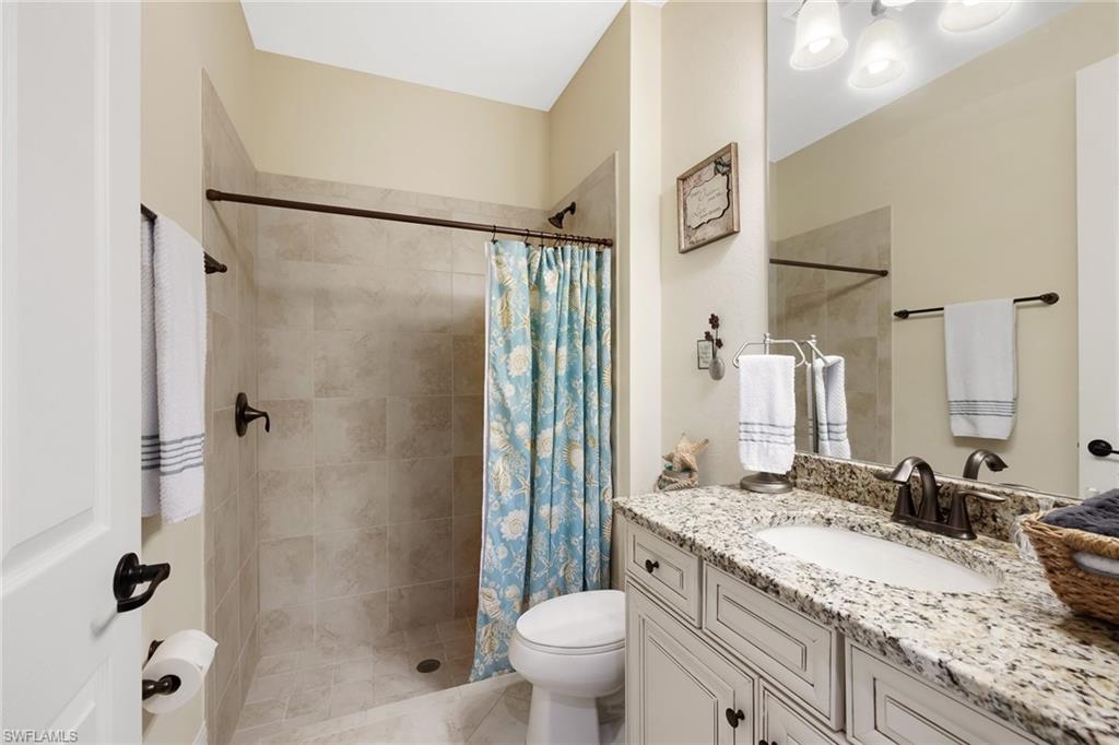 28529 Westmeath Court Bonita Springs, FL 34135 - Photo 18 of 49 a bathroom with a granite countertop sink toilet and shower