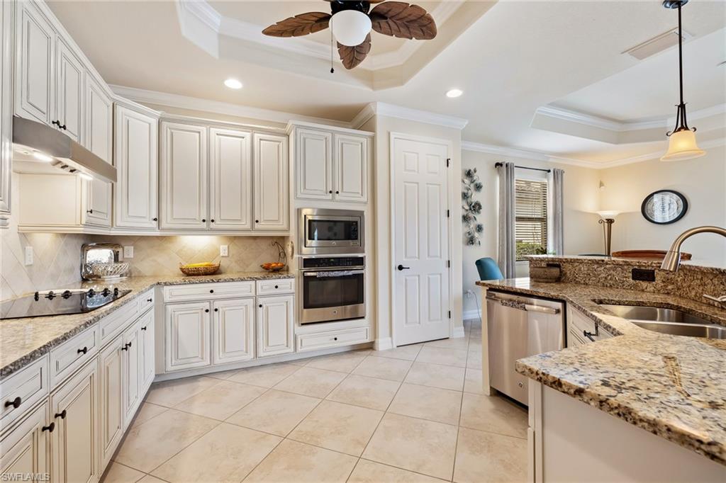 28529 Westmeath Court Bonita Springs, FL 34135 - Photo 7 of 49 a kitchen with stainless steel appliances granite countertop a stove top oven a sink a counter space and cabinets