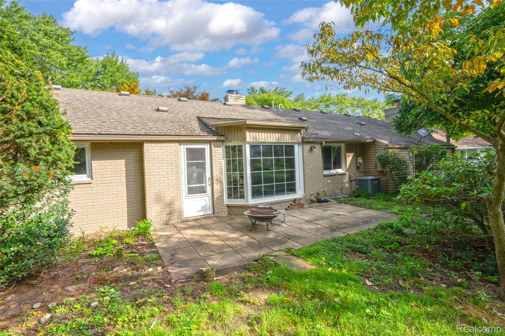 2329 Rutherford Road Bloomfield Hills, MI 48302 - Photo 11 of 46 Brick exterior with a bay window, concrete patio, and mature landscaping