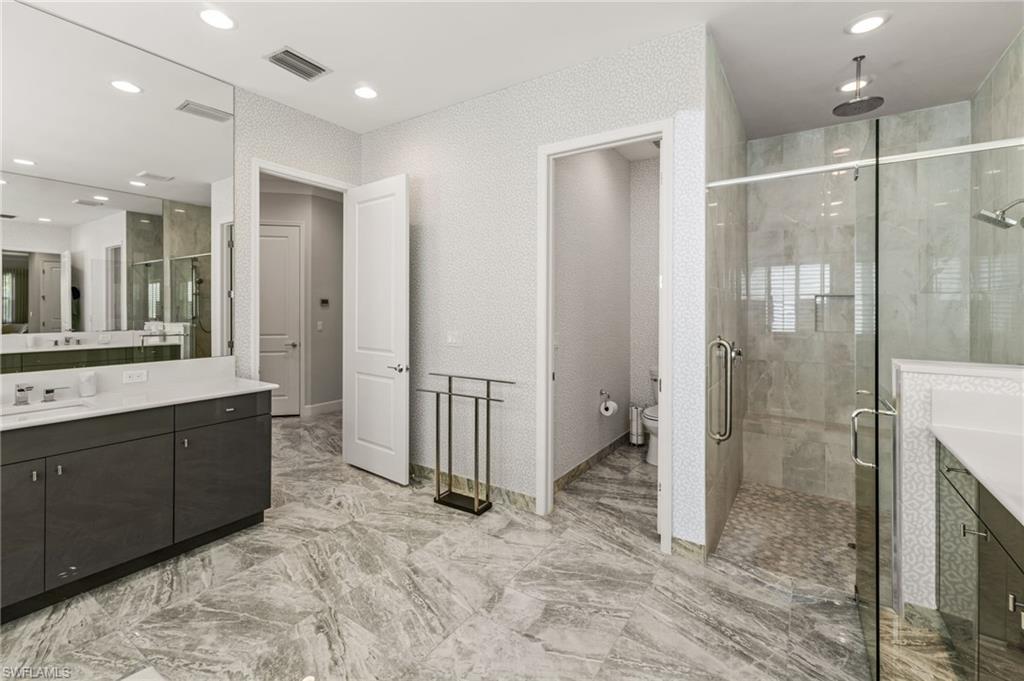 12033 Azalea Way Naples, FL 34120 - Photo 15 of 46 Primary suite bathroom with dual vanities, large walk in shower, water closet.