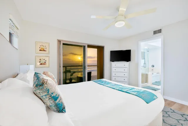 a bedroom with a large bed and a flat screen tv