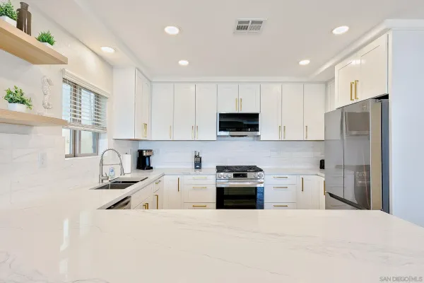 a kitchen with white cabinets stainless steel appliances and sink