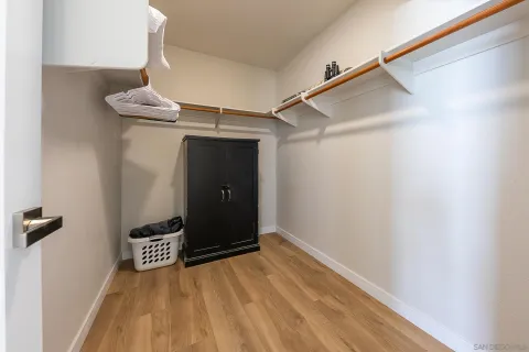 a spacious bedroom with a bed and a flat screen tv