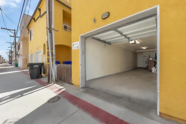 a front view of a multi story residential apartment building with garage and parking space