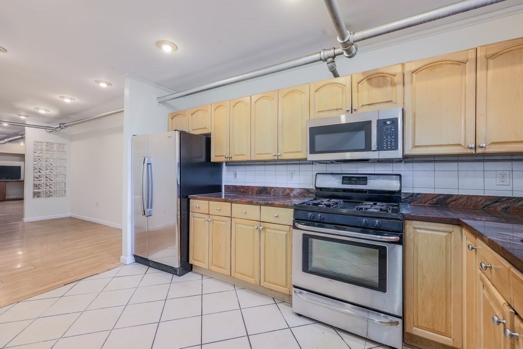 52 Garden Street, Unit B2 Cambridge, MA 02138 - Photo 2 of 17 a kitchen with stainless steel appliances granite countertop a stove top oven microwave and cabinets
