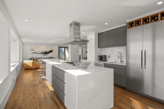 a kitchen with kitchen island a sink stove and refrigerator