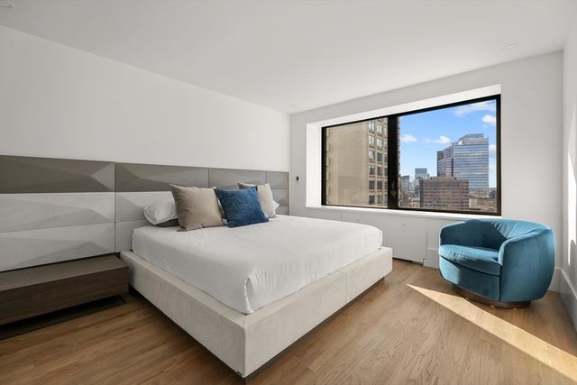 a bed sitting in a bedroom next to a window with couch