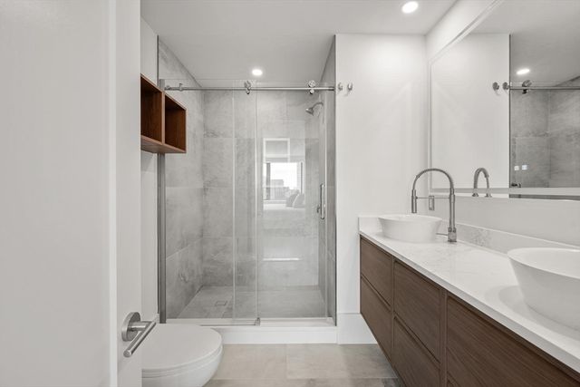 a bathroom with a sink shower and a mirror