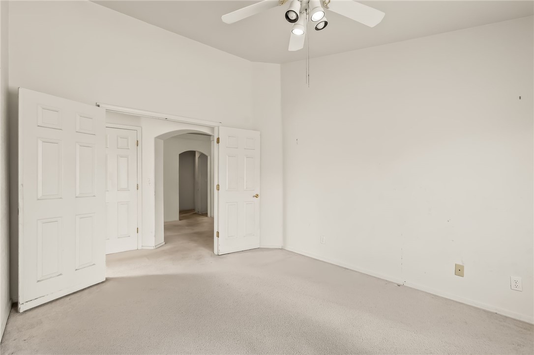 2853 Winchester Road Bullhead City, AZ 86442 - Photo 9 of 40 This room features light-colored carpeting, a ceiling fan with integrated lighting, and multiple paneled doors