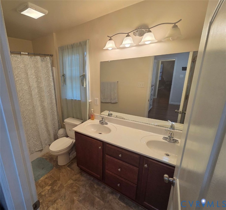 4504 Warwick Road Richmond, VA 23234 - Photo 12 of 15 a bathroom with a double vanity sink and mirror with toilet