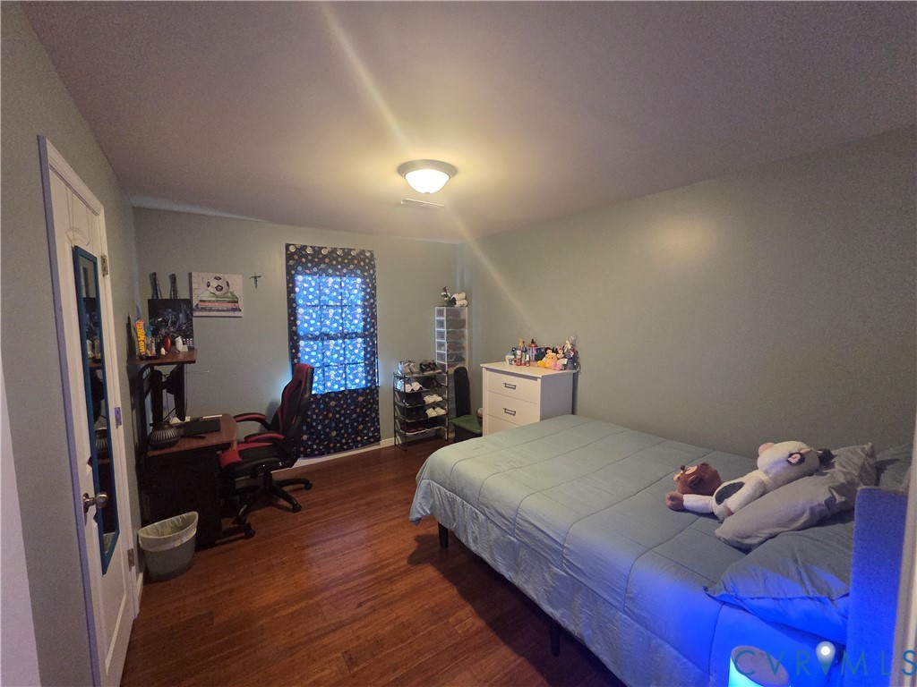4504 Warwick Road Richmond, VA 23234 - Photo 8 of 15 a bedroom with a bed and a wooden floor