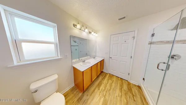 a view of a white house with a big yard and large tree